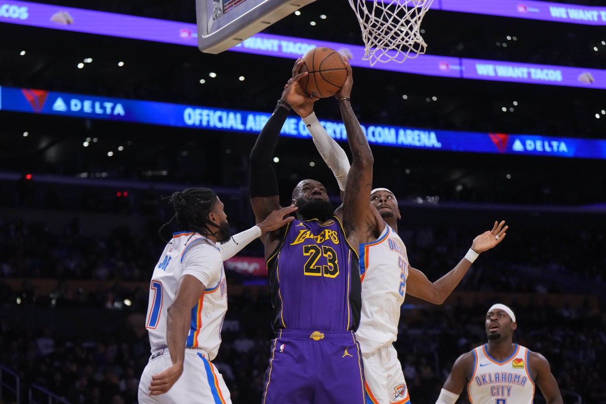 Nov 29, 2024; Los Angeles, California, USA; Los Angeles Lakers forward LeBron James (23) shoots the ball against Oklahoma City Thunder guard Shai Gilgeous-Alexander (2) and guard Isaiah Joe (11) in the first half at Crypto.com Arena. Mandatory Credit: Kirby Lee-Imagn Images