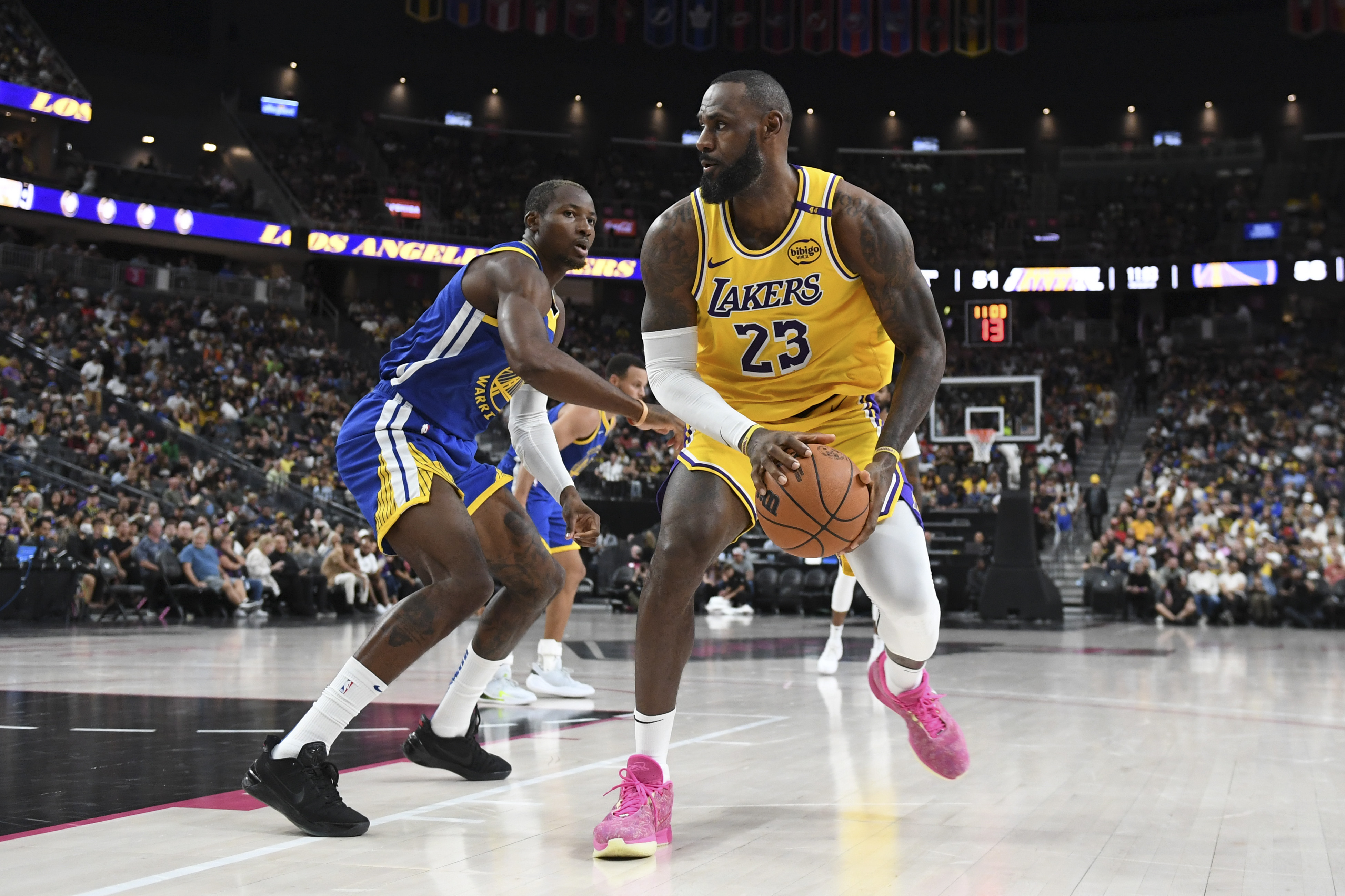 Oct 15, 2024; Las Vegas, Nevada, USA; Los Angeles Lakers forward LeBron James (23) dribbles past Golden State Warriors forward Jonathan Kuminga (00) in the third quarter during a preseason game at T-Mobile Arena. Mandatory Credit: Candice Ward-Imagn Images