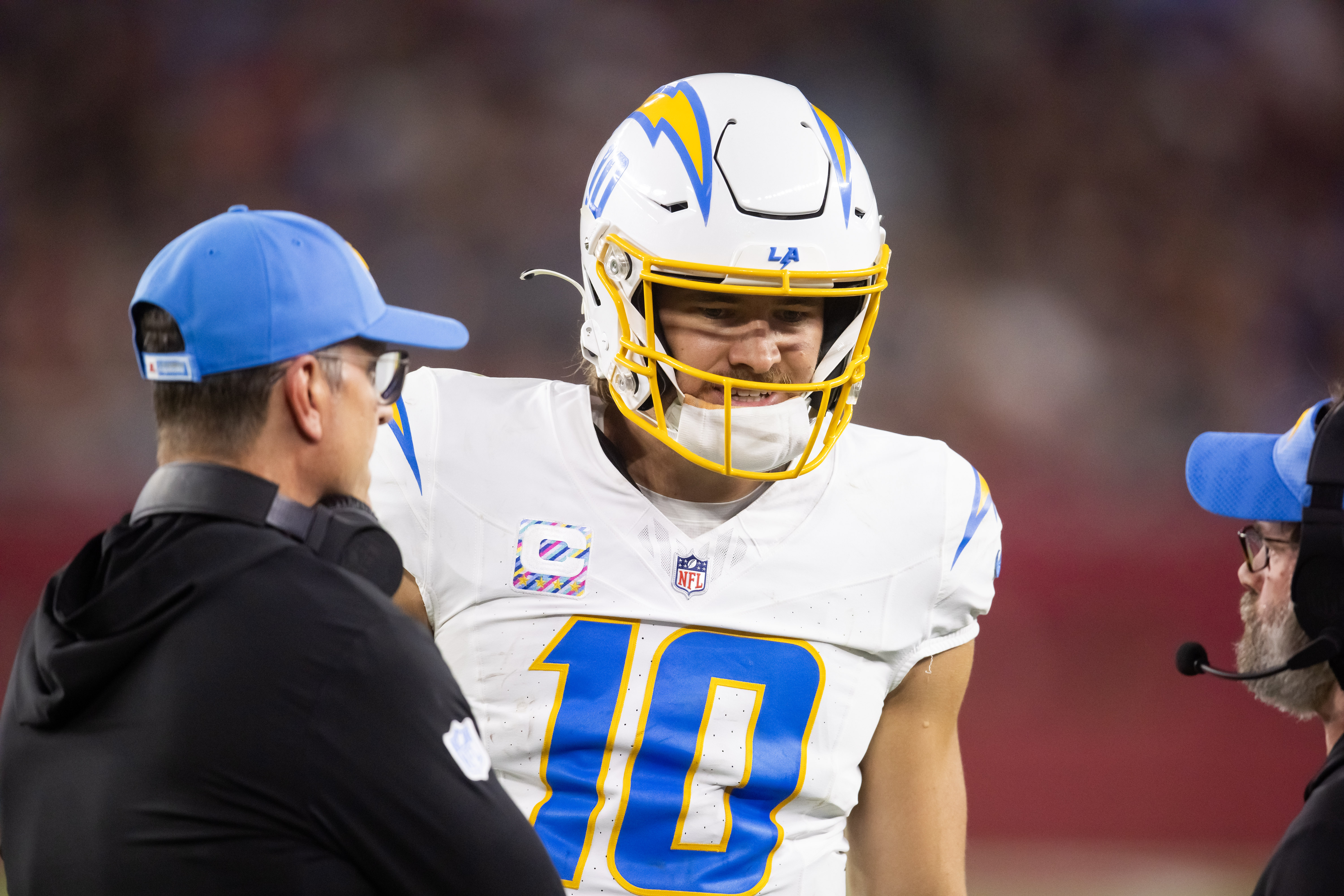 Oct 21, 2024; Glendale, Arizona, USA; Los Angeles Chargers quarterback Justin Herbert (10) with head coach Jim Harbaugh against the Arizona Cardinals at State Farm Stadium. Mandatory Credit: Mark J. Rebilas-Imagn Images