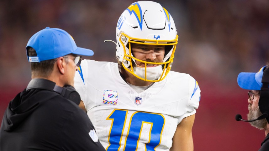 Oct 21, 2024; Glendale, Arizona, USA; Los Angeles Chargers quarterback Justin Herbert (10) with head coach Jim Harbaugh against the Arizona Cardinals at State Farm Stadium. Mandatory Credit: Mark J. Rebilas-Imagn Images