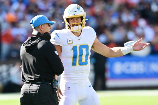 Nov 3, 2024; Cleveland, Ohio, USA; Los Angeles Chargers quarterback Justin Herbert (10) talks to head coach Jim Harbaugh during the first quarter against the Cleveland Browns at Huntington Bank Field. Mandatory Credit: Ken Blaze-Imagn Images