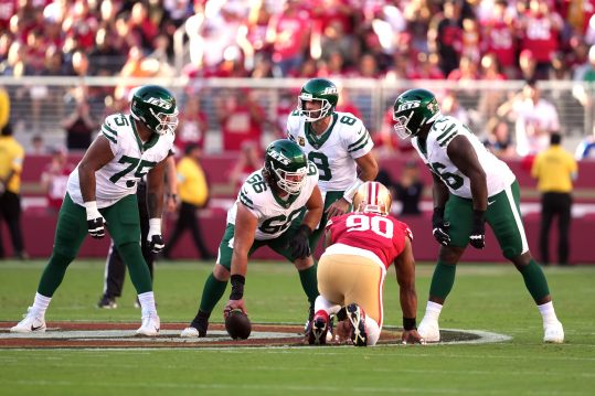 Sep 9, 2024; Santa Clara, California, USA; New York Jets quarterback Aaron Rodgers (8) talks with guards Alijah Vera-Tucker (75) and John Simpson (76) and center Joe Tippmann (66) before a snap against the San Francisco 49ers during the first quarter at Levi's Stadium. Mandatory Credit: Darren Yamashita-Imagn Images