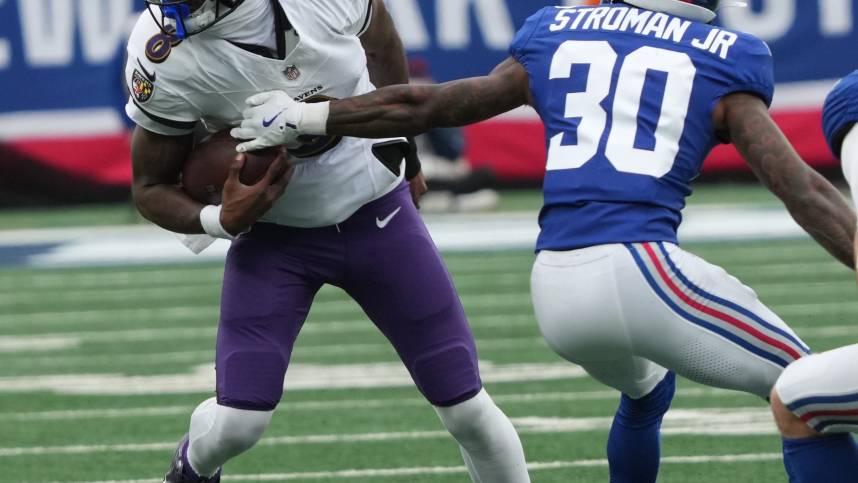 East Rutherford, NJ -- December 15, 2024 -- Lamar Jackson of the Ravens and Greg Stroman Jr. of the Giants in the first half. The Baltimore Ravens came to MetLife Stadium to play the New York Giants.