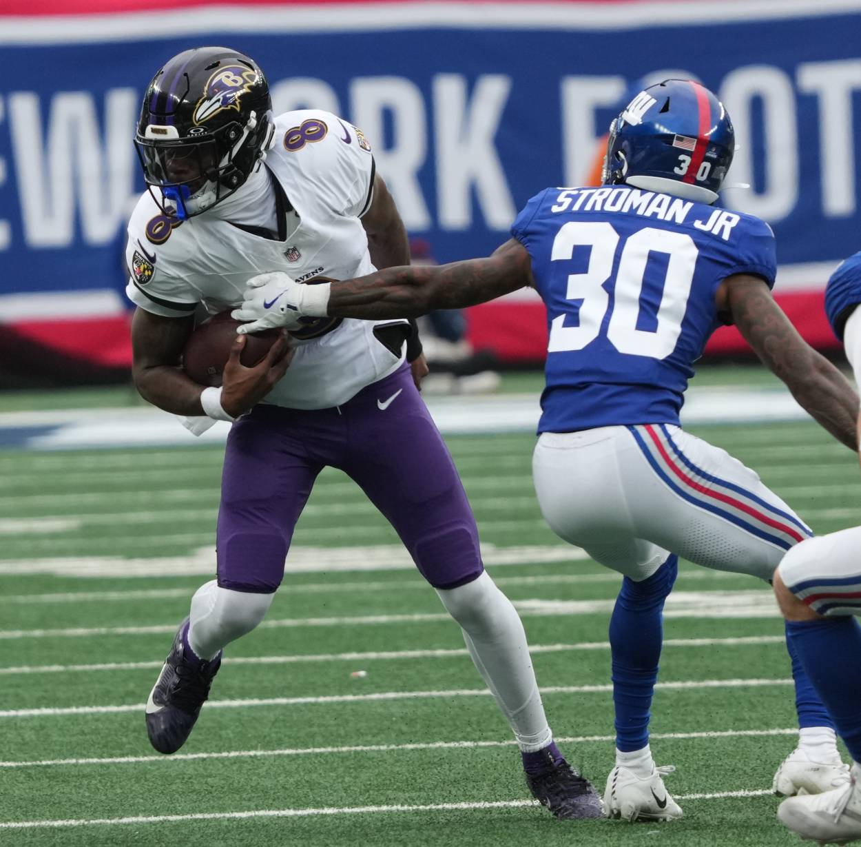 East Rutherford, NJ -- December 15, 2024 -- Lamar Jackson of the Ravens and Greg Stroman Jr. of the Giants in the first half. The Baltimore Ravens came to MetLife Stadium to play the New York Giants.