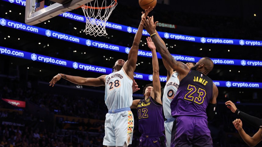 Jan 13, 2025; Los Angeles, California, USA;  San Antonio Spurs center Charles Bassey (28) rebounds a ball against Los Angeles Lakers guard Max Christie (12) and forward LeBron James (23) during the second half at Crypto.com Arena. Mandatory Credit: Kiyoshi Mio-Imagn Images