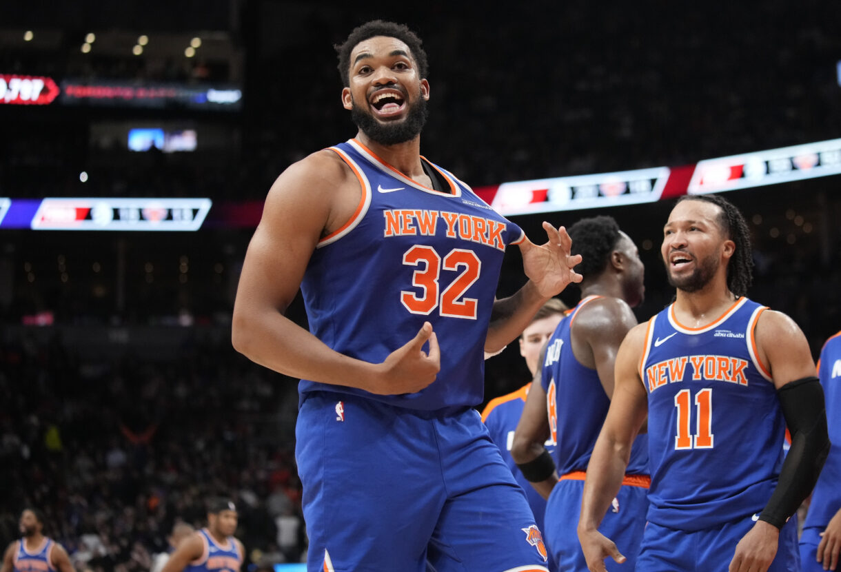 Dec 9, 2024; Toronto, Ontario, CAN; New York  Knicks guard Jalen Brunson (11) watches as center Karl-Anthony Towns (32) celebrates after making a three point basket to clinch a win against the Toronto Raptors near the end of the fourth quarter at Scotiabank Arena. Mandatory Credit: John E. Sokolowski-Imagn Images