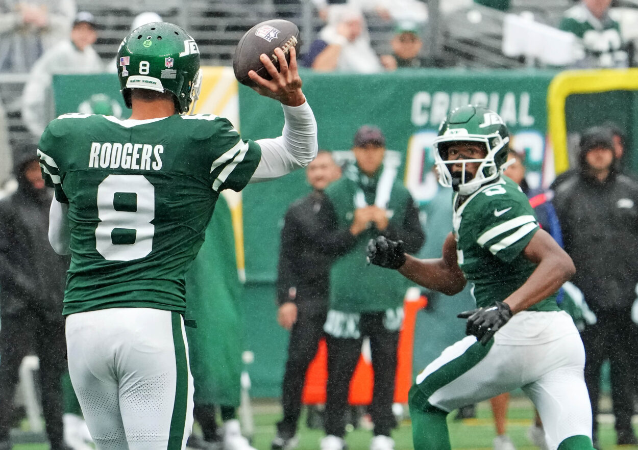 Sep 29, 2024; East Rutherford, New Jersey, USA;  New York Jets quarterback Aaron Rodgers (8) throws complete pass to wide receiver Garrett Wilson (5) against the Denver Broncos in the second half at MetLife Stadium. Mandatory Credit: Robert Deutsch-Imagn Images