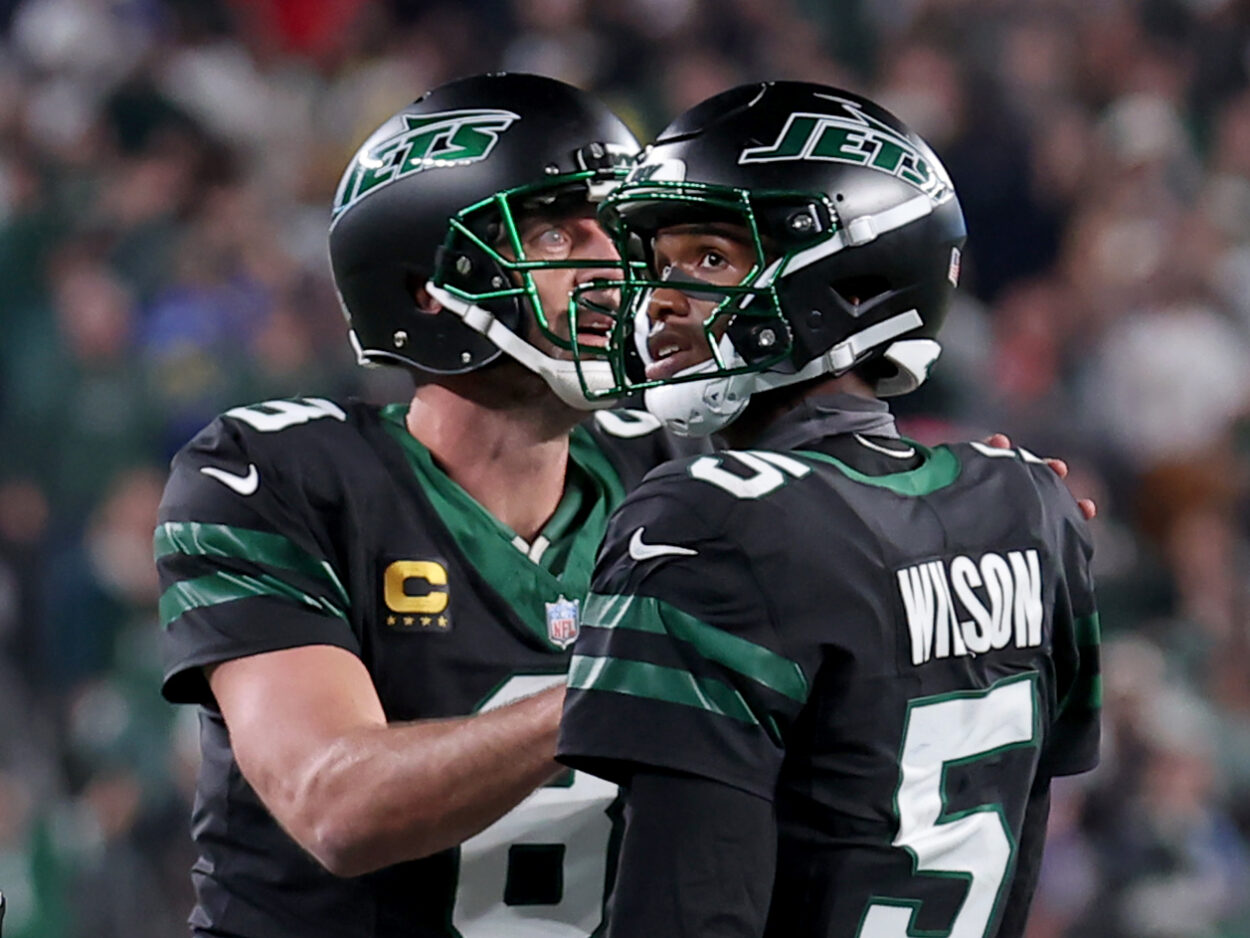 Oct 31, 2024; East Rutherford, New Jersey, USA; New York Jets quarterback Aaron Rodgers (8) and wide receiver Garrett Wilson (5) watch a video replay of their touchdown against the Houston Texans during the fourth quarter at MetLife Stadium. Mandatory Credit: Brad Penner-Imagn Images