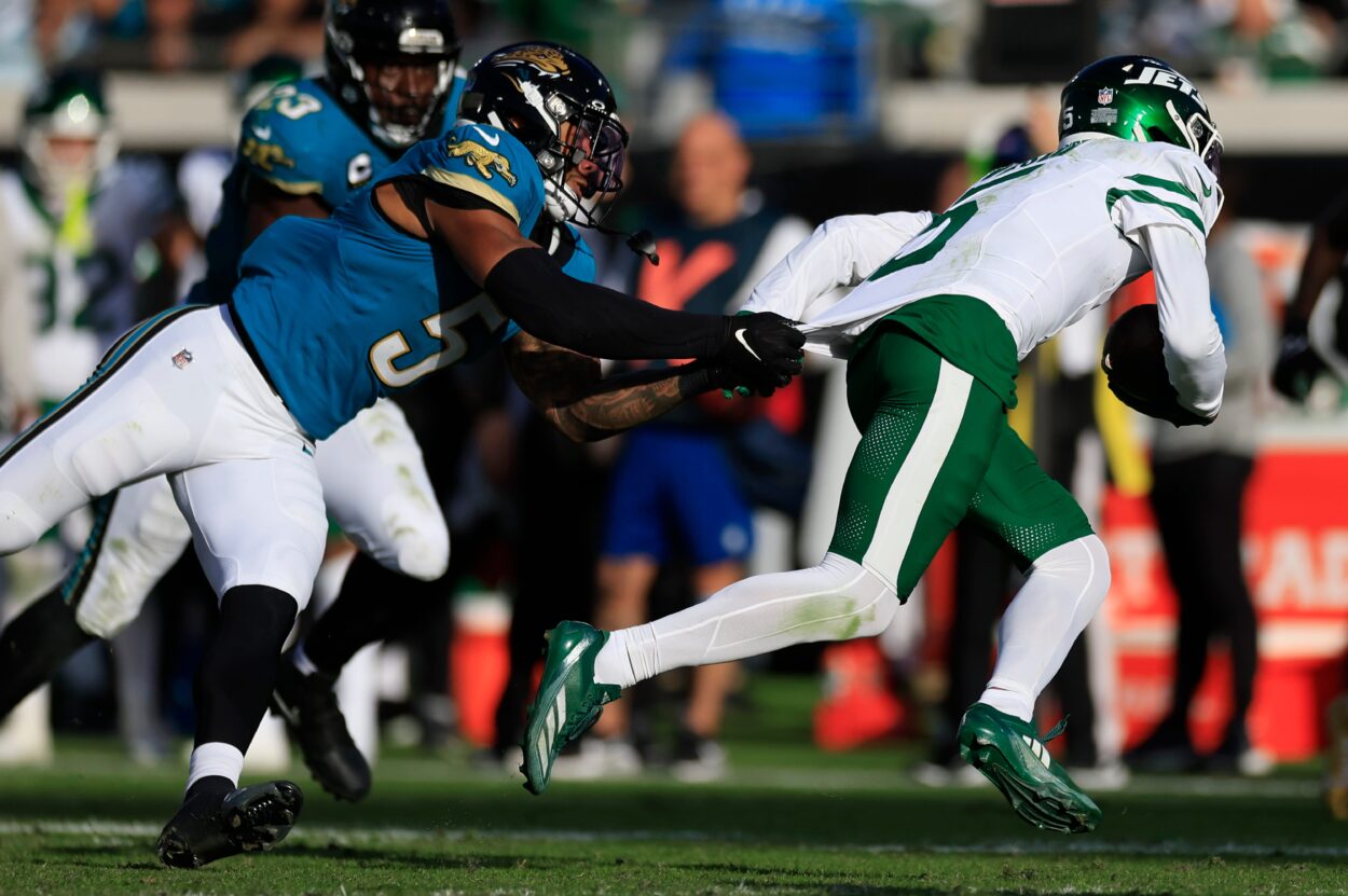 Jacksonville Jaguars safety Andre Cisco (5), left, tackles New York Jets wide receiver Garrett Wilson (5) during the fourth quarter Sunday, Dec. 15, 2024 at EverBank Stadium in Jacksonville, Fla. The Jets held off the Jaguars 32-25. [Corey Perrine/Florida Times-Union]