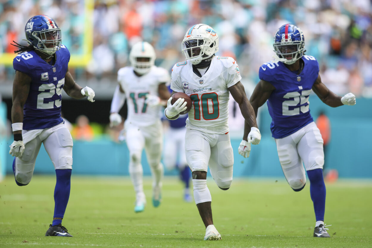 Oct 8, 2023; Miami Gardens, Florida, USA; Miami Dolphins wide receiver Tyreek Hill (10) runs with the football ahead of New York Giants cornerback Deonte Banks (25) and safety Xavier McKinney (29) during the second quarter at Hard Rock Stadium. Mandatory Credit: Sam Navarro-Imagn Images